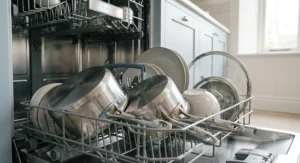 All three saucepans from the set nestled perfectly together in a vertical stack with the matching lids placed neatly beside them to show space-saving storage.