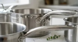Close-up detail of sturdy riveted stainless steel handles on a high-quality saucepan set.